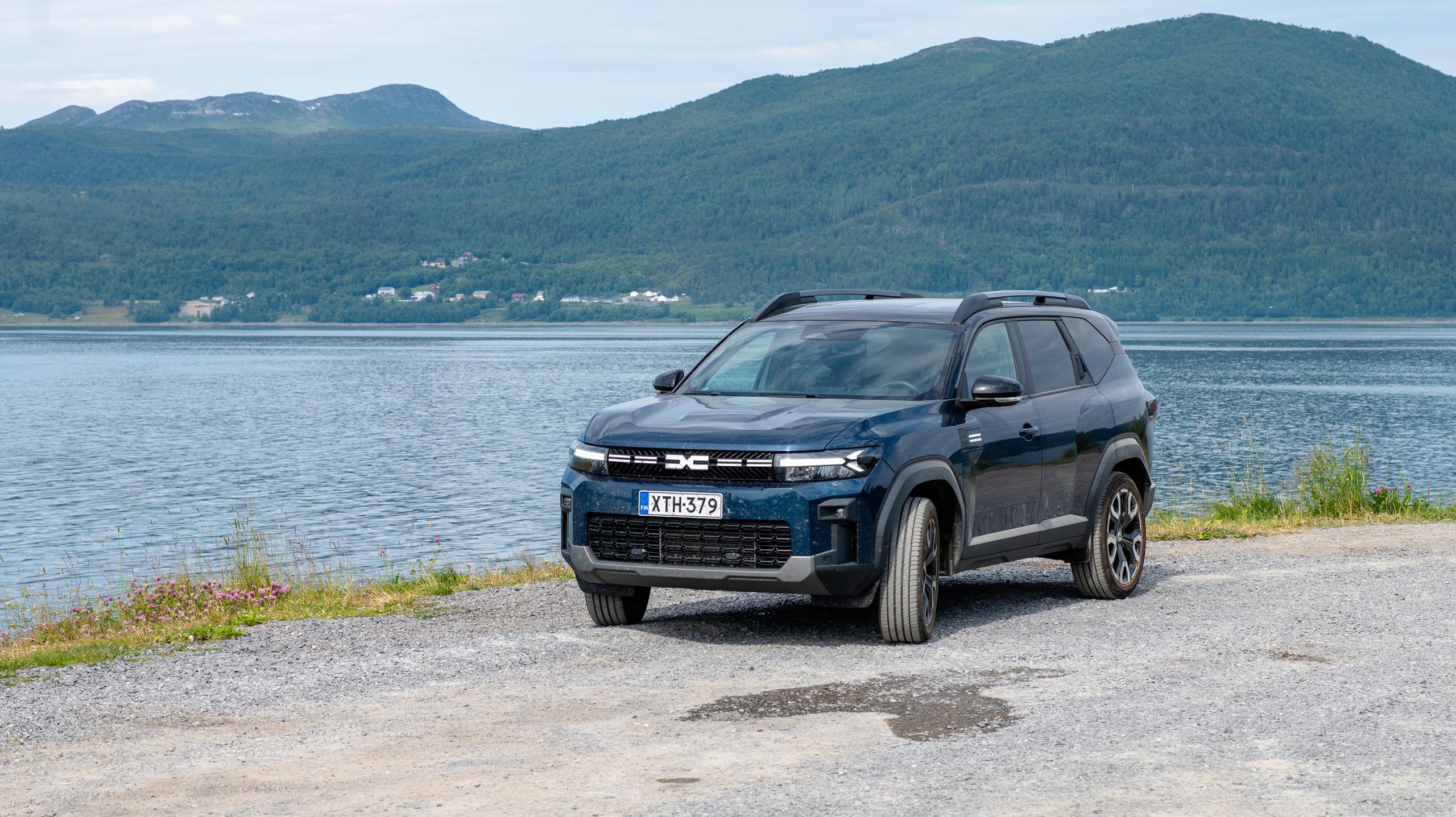 Sininen Bigster rannassa, takana vuoristoa